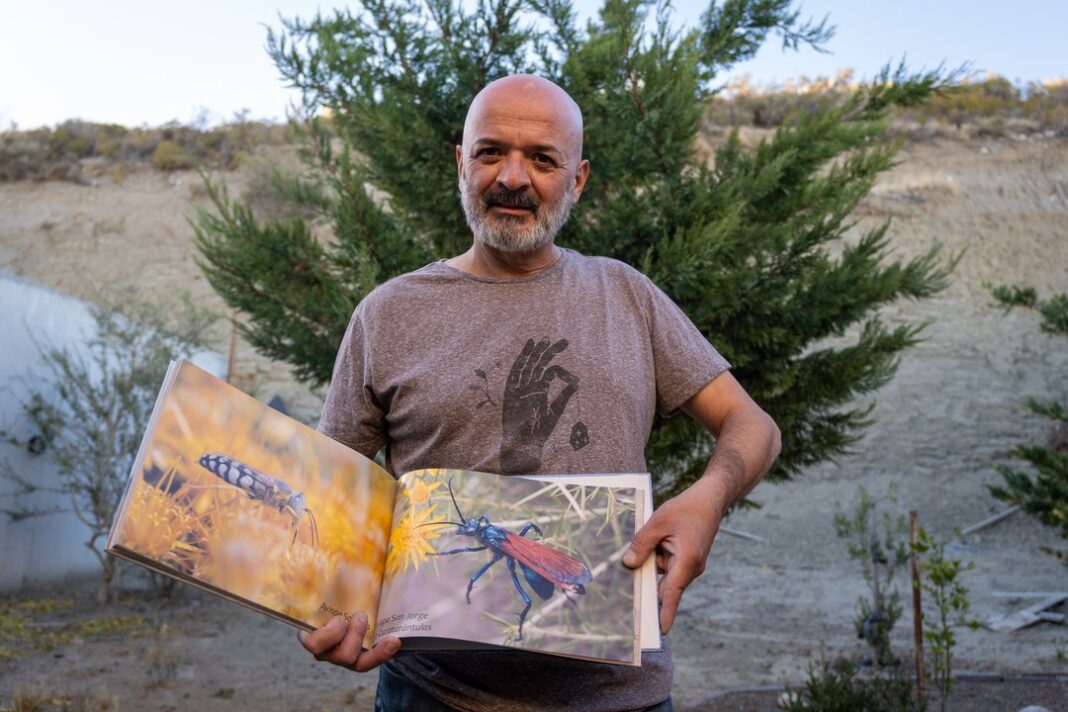 Daniel Vaquero, fotógrafo, observando aves con su cámara en un paisaje de Chubut.