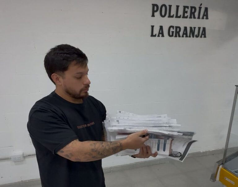 Fila de personas con currículums en la puerta de la pollería La Granja en Comodoro Rivadavia