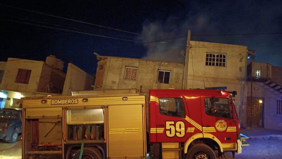 Bomberos trabajando en el incendio de una vivienda precaria en Comodoro Rivadavia