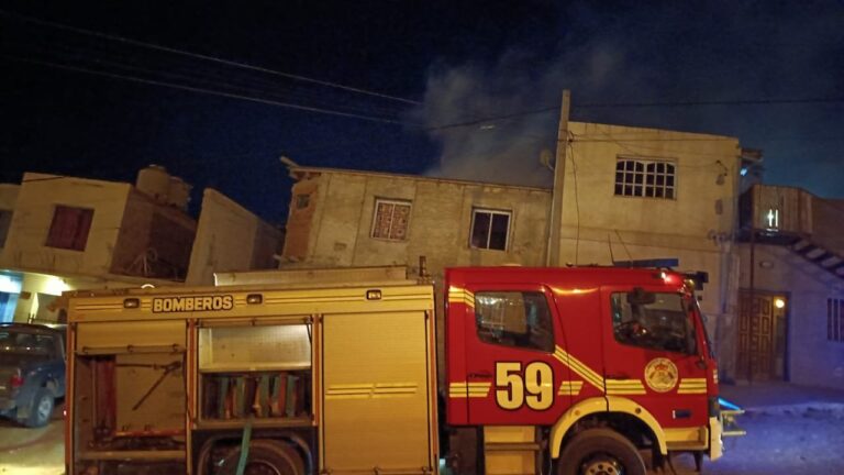 Bomberos trabajando en el incendio de una vivienda precaria en Comodoro Rivadavia