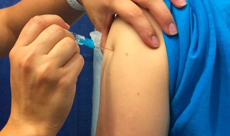 Persona recibiendo vacuna antigripal en un centro de salud