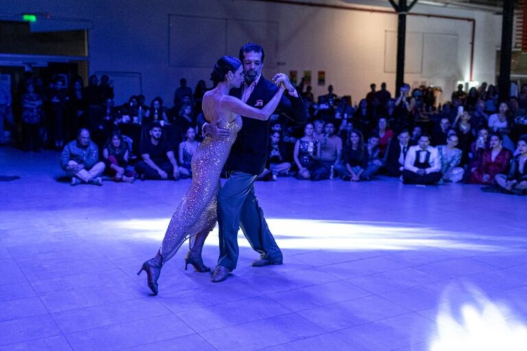Parejas de tango bailando en el escenario del Centro Cultural de Comodoro Rivadavia durante el Festival Tango BA 2026