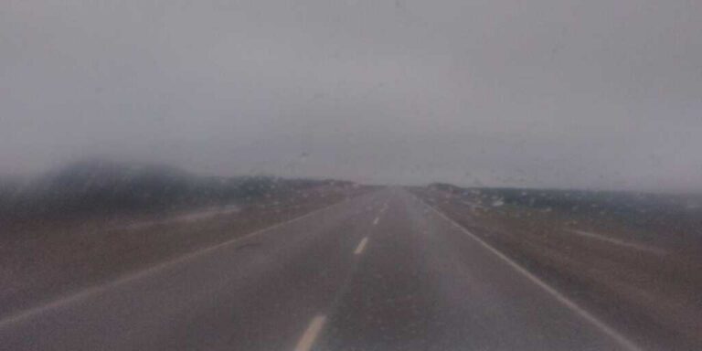 Ambulancia y bomberos trabajando en la Ruta 3 bajo lluvia tras un vuelco