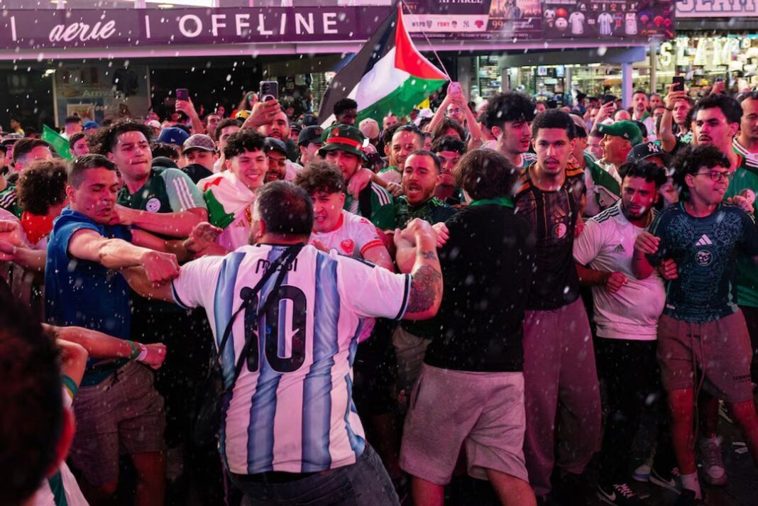 Personas corriendo en Times Square durante enfrentamientos entre hinchas argentinos y argelinos