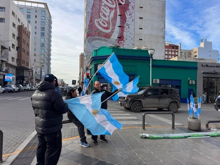 Vendedores ambulantes en el centro de Comodoro Rivadavia con banderas argentinas y camisetas previo al partido Argentina vs Inglaterra