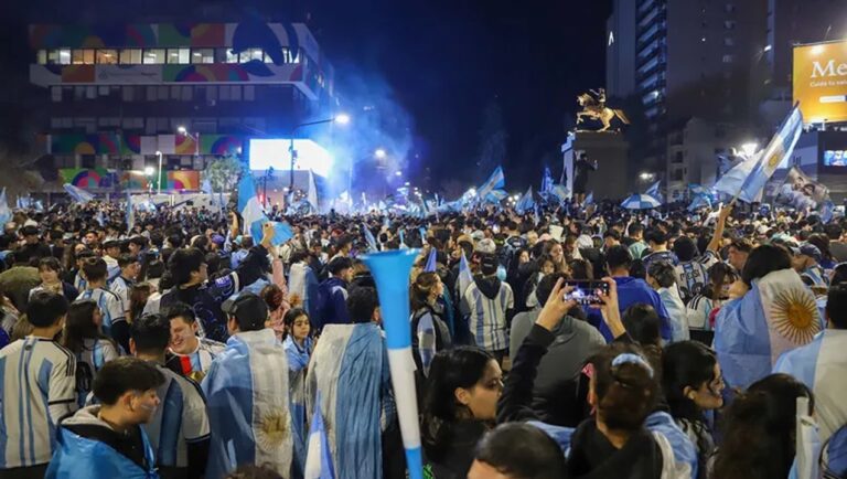 Personas festejando en una calle de Neuquén con banderas argentinas