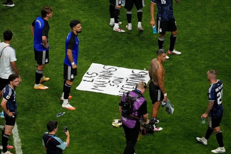 Jugadores argentinos sostienen bandera con leyenda Las Malvinas son argentinas