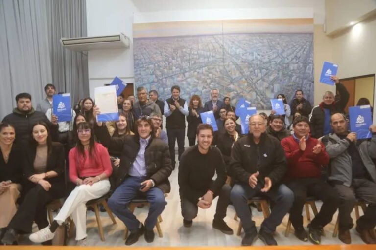 Familias recibiendo escrituras en acto municipal en Neuquén