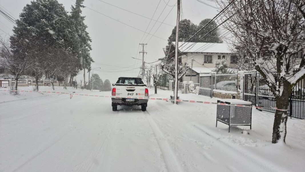 Nevada en la cordillera de Río Negro con calles cubiertas de nieve y vehículos circulando con cadenas