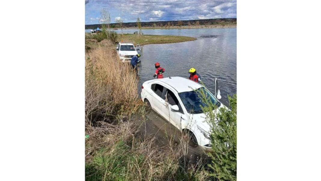 Auto Fiat Cronos blanco recostado sobre un costado a orillas del río en Senillosa