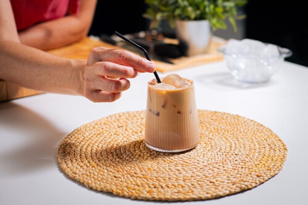 Café helado con crema de cacao y avellanas en un vaso con hielo