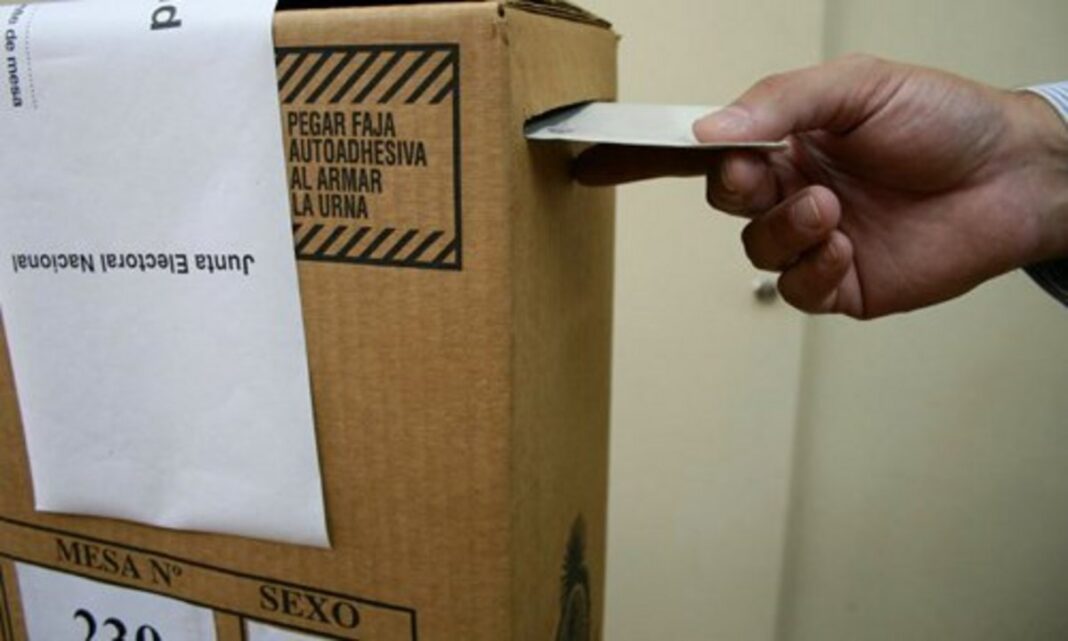 Urna electoral y boletas en mesa de votación