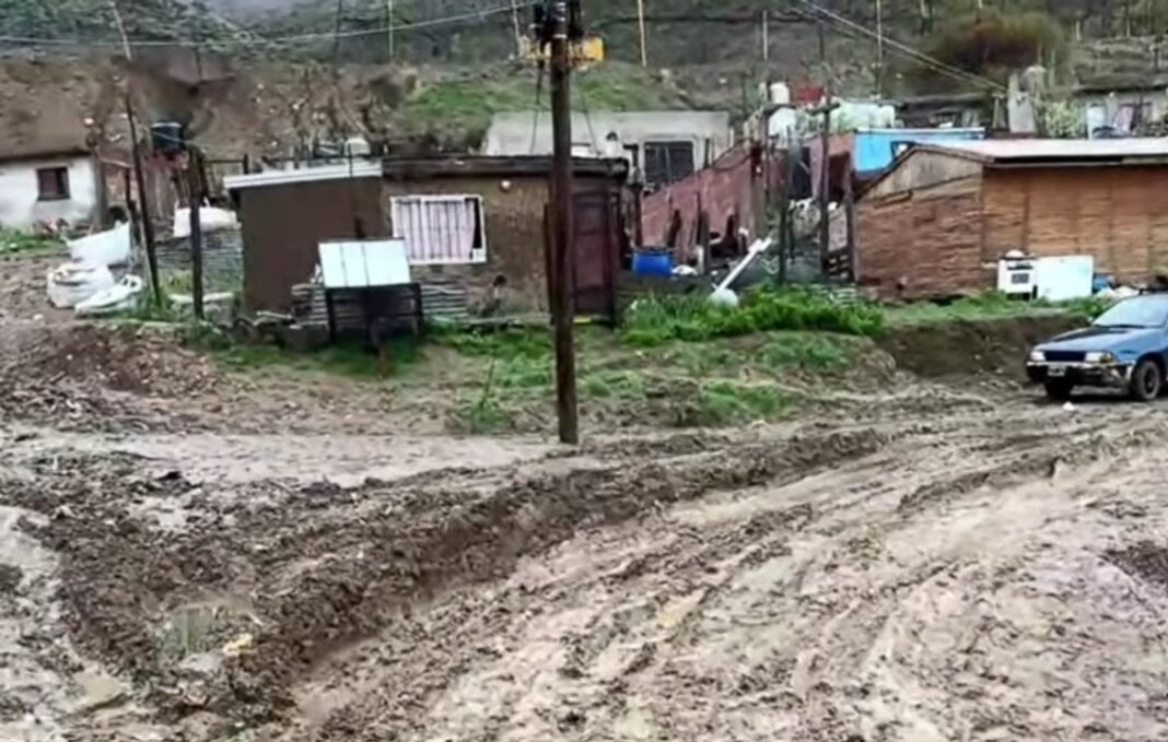 Calle de tierra anegada y con barro en el barrio La Floresta de Comodoro Rivadavia