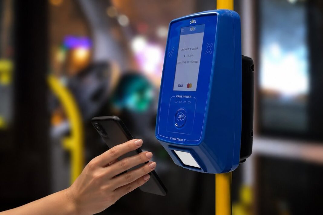 Persona pagando colectivo con celular mediante tecnología NFC
